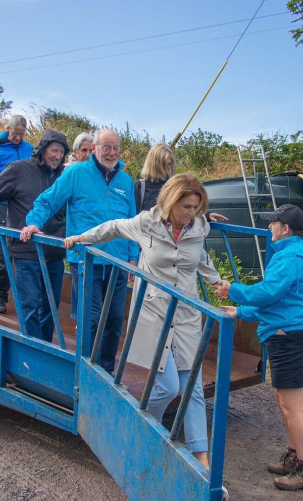 Visitors getting off tractor trailer - crop