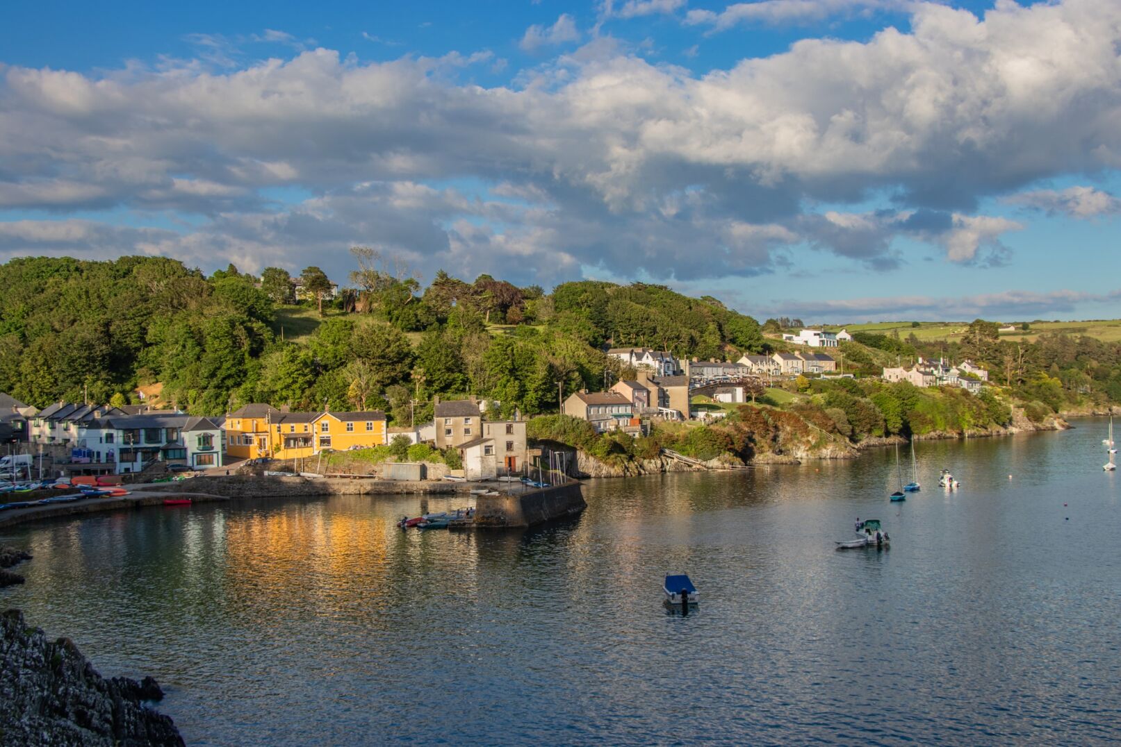 View of village on estuary with boats in foreground