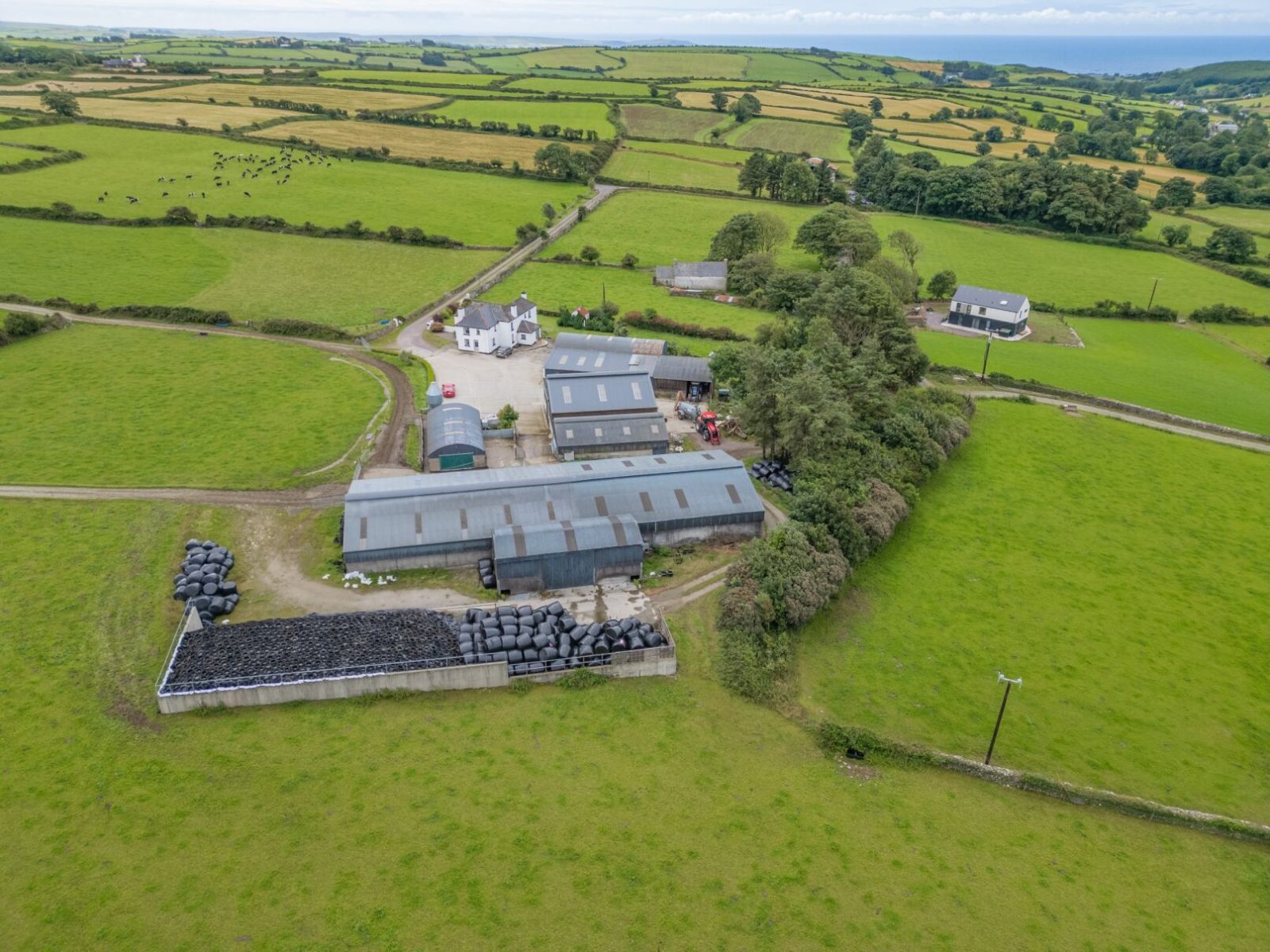 Drone shot of farm sheds surrounded by fields